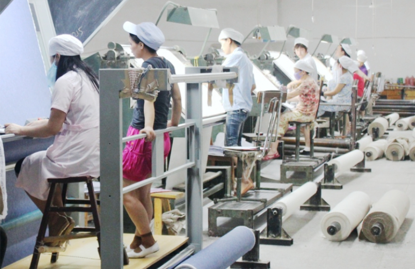 Workers inspecting fabric